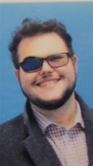 A picture of a bearded man with an eyepatch and glasses.